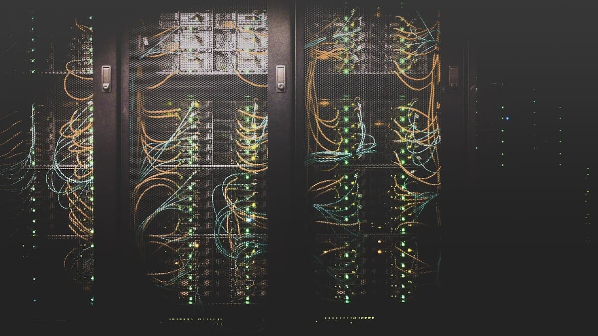 Serverrack med nätverkskablar och lysande statuslampor i en serverhall